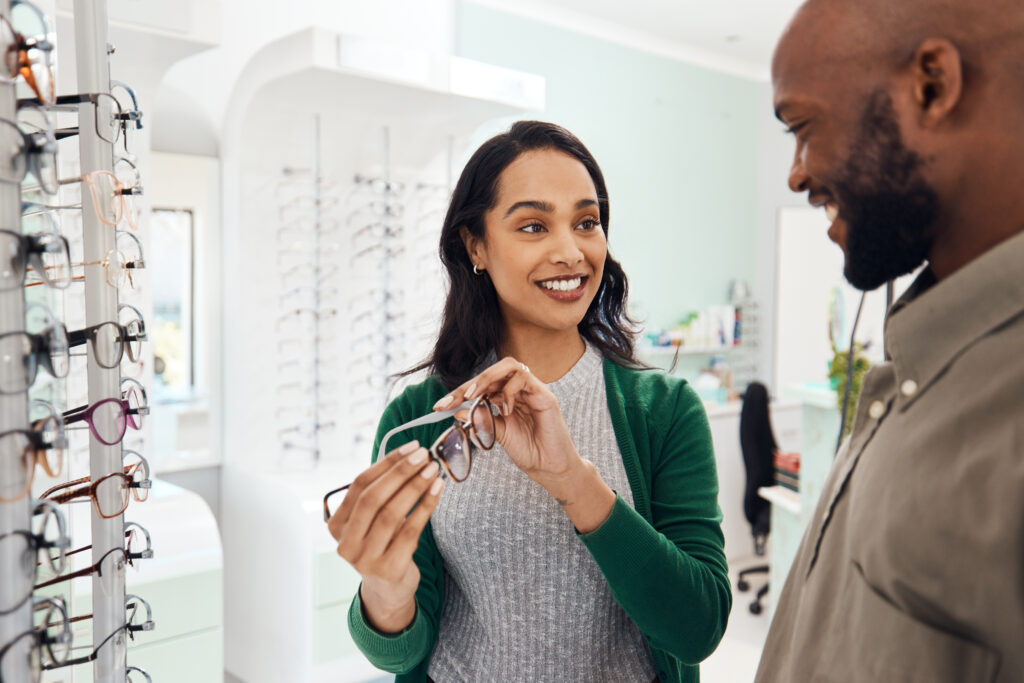 Optician helping patient choose transition lenses at clinic