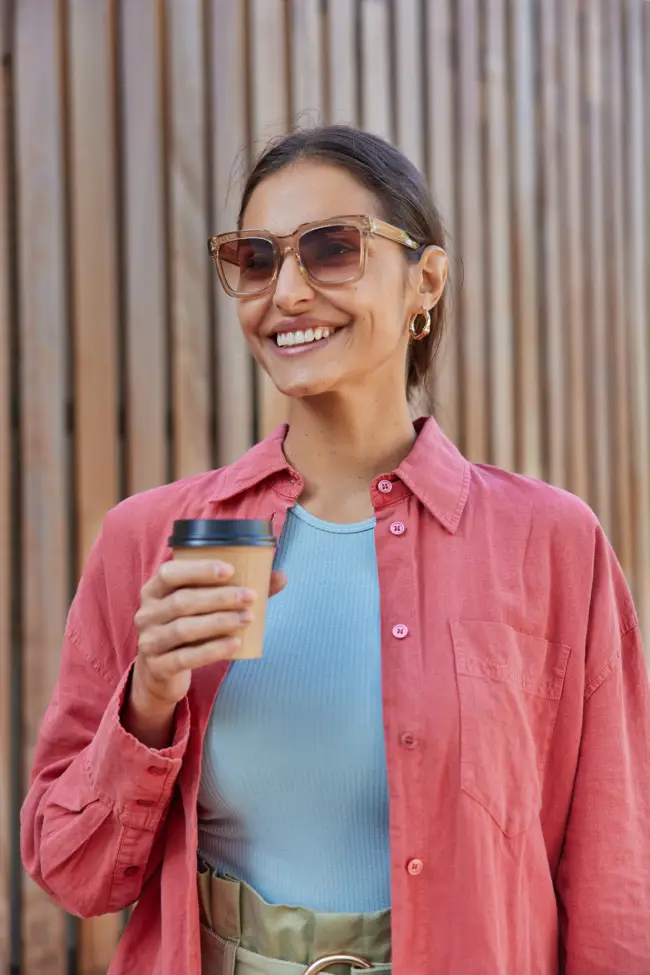 Young woman wearing glasses outdoors in sunlight